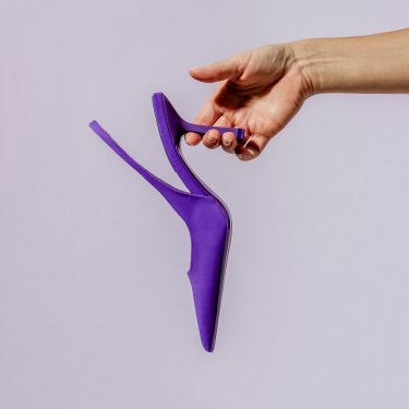 Hand holding purple high heel