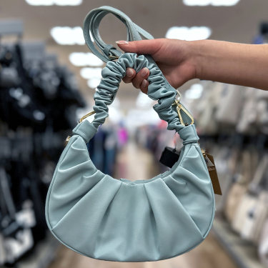 Hand holding light blue pleated bag