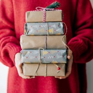 person in red sweater carrying presents