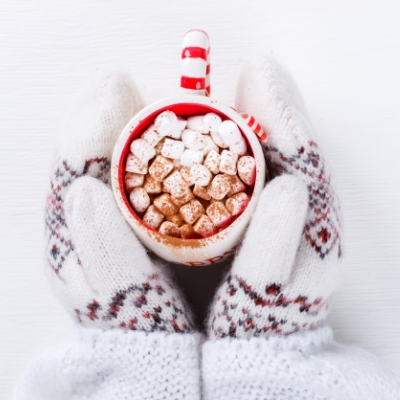 Holi-400x400 – 6 (1) mittened hands holding a cup of hot chocolate with marshmallows