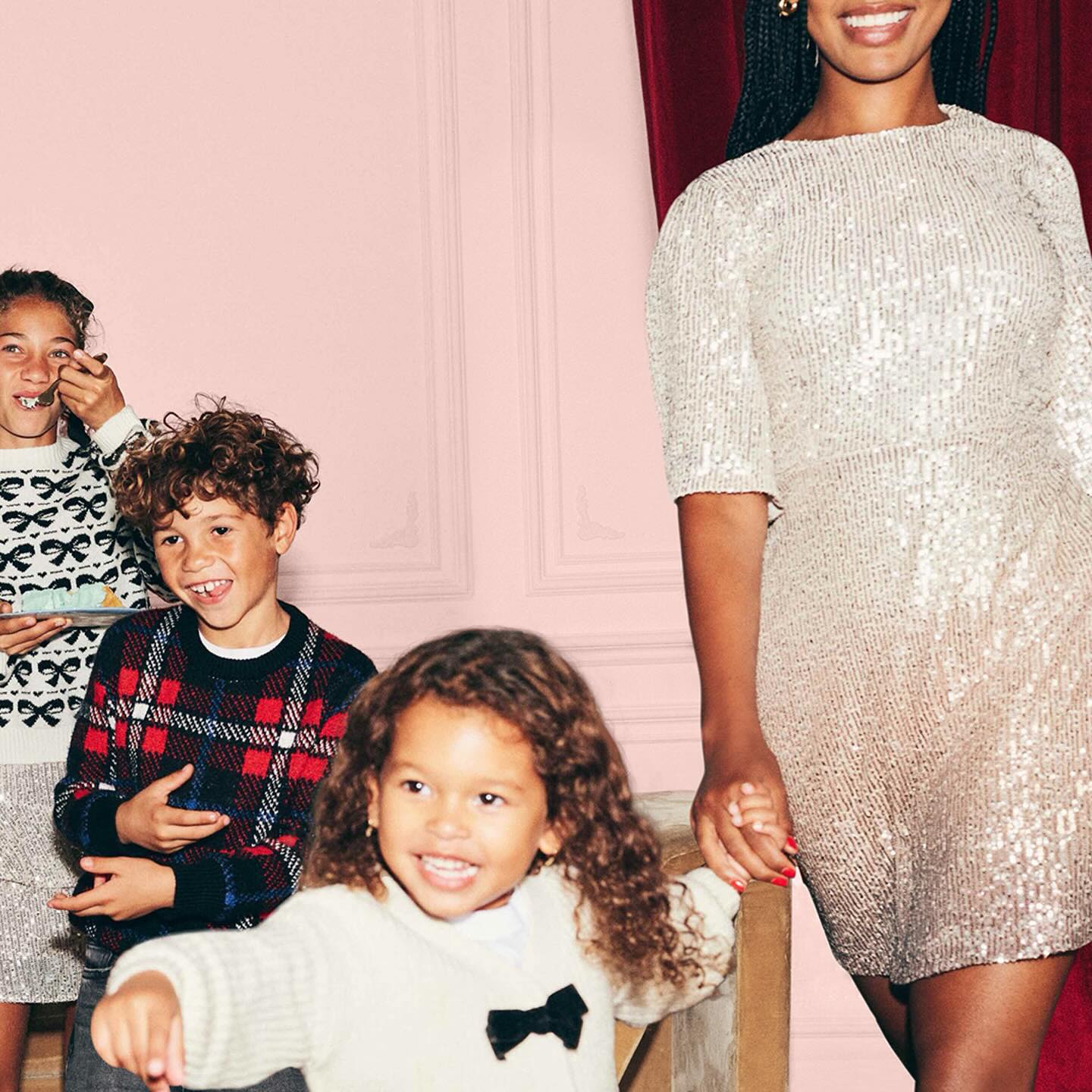 Smiling children with a woman dressed in holiday clothes from Old Navy